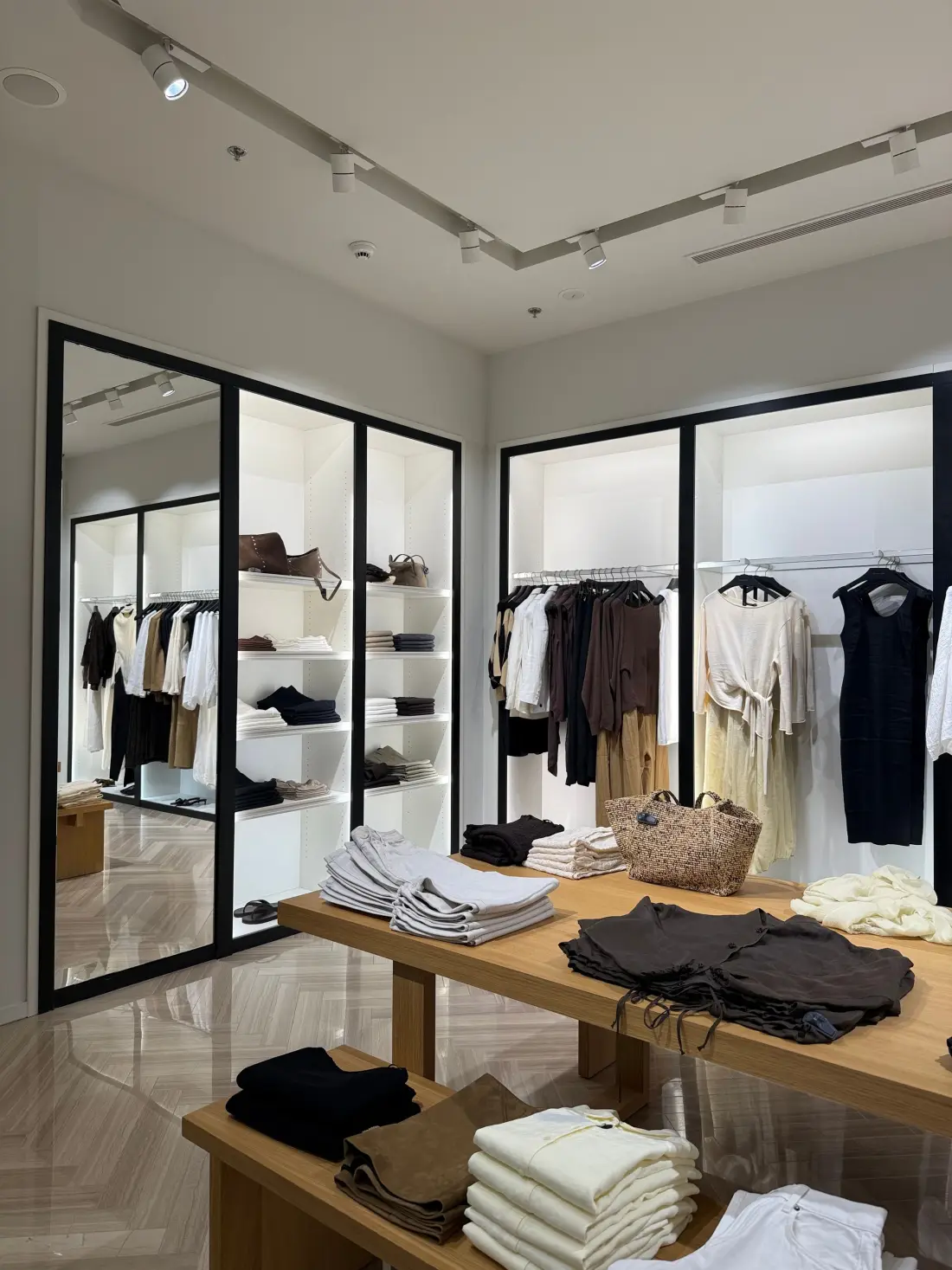 Boutique shop interior with glass-fronted display cabinets, track lighting and a timber table